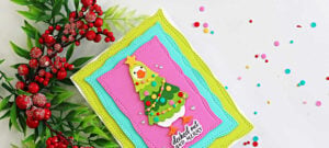 Handmade Christmas card featuring a silly goose dressed as a Christmas tree, framed by colorful stitched zigzag panels, created with the Spellbinders Lit with Joy dies.