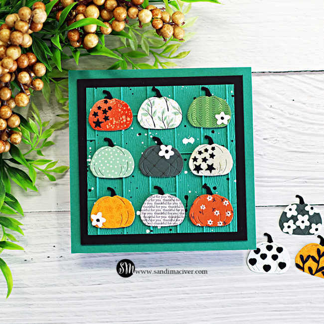 Die cut Thanksgiving card with nine patterned pumpkins arranged in a grid on a teal embossed wooden plank background with black matting, featuring small flowers, stars, splatter, and a pumpkin printed with “thankful for you.”